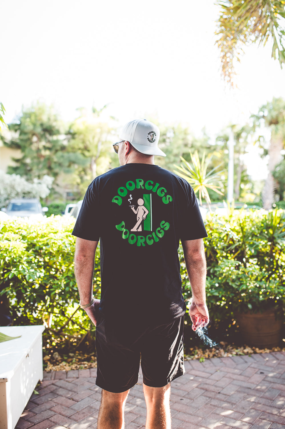 men’s retro graphic tee streetwear on a smoke break in a crisp white snapback